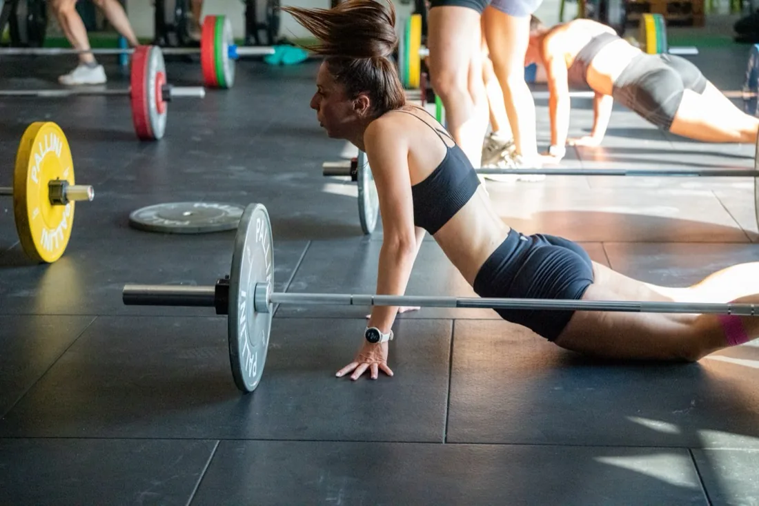 Entraînement de groupe au sol avec barres et disques à CrossFit Le Puy